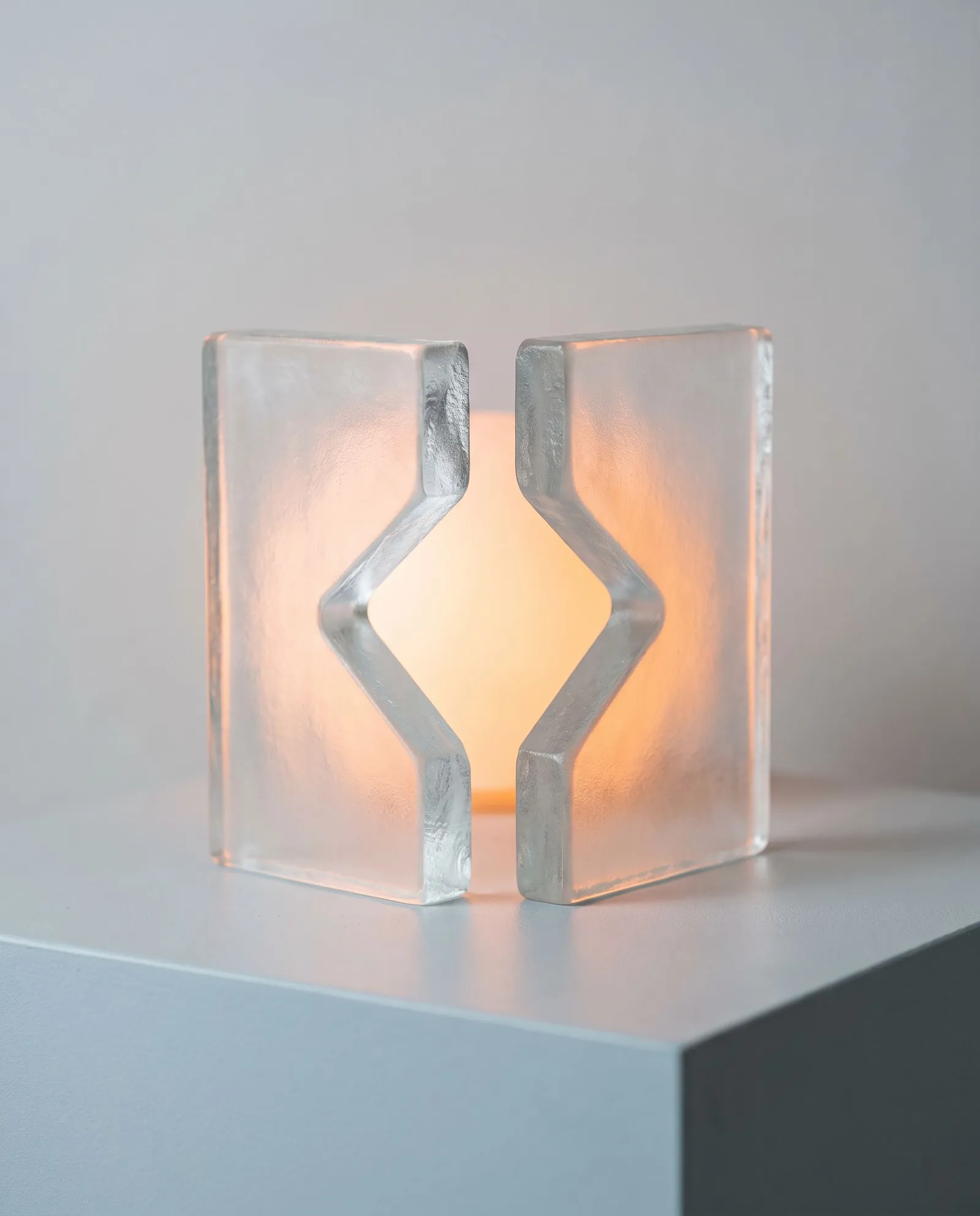 Two frosted glass brackets with warm orange light glowing in the gap between them