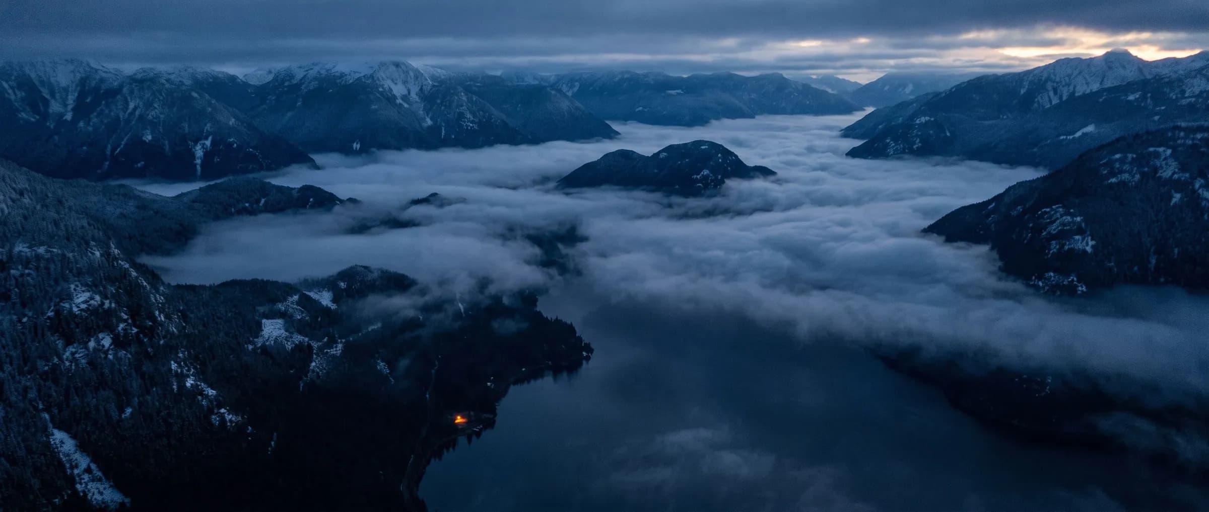 Aerial view of the British Columbia Coast Mountains at dawn with fog in the valleys